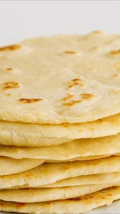 a stack of tortillas sitting on top of a white plate