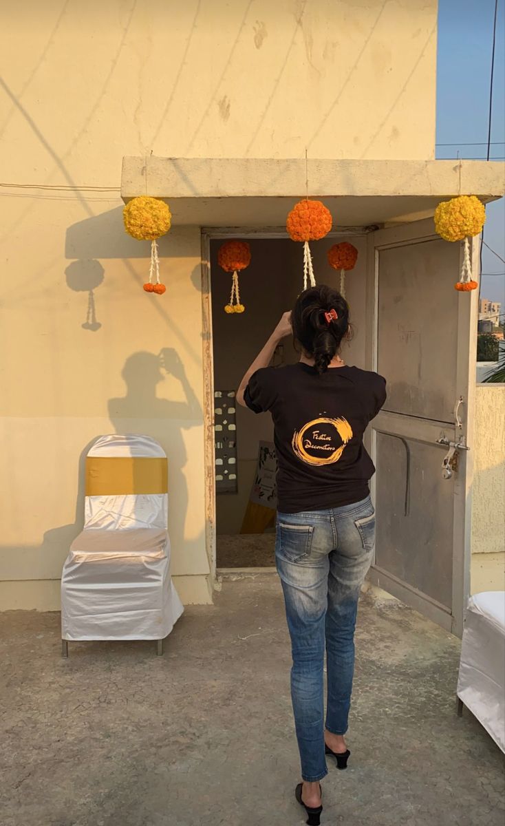 a woman is standing in front of a building with decorations on the door and windows