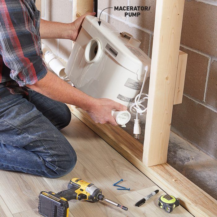 a man is working on an electrical outlet in the wall next to his workbench