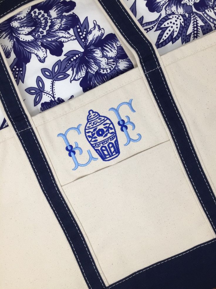 an embroidered tote bag with blue flowers on it