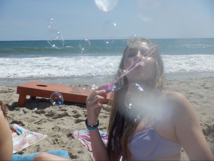 a girl blowing bubbles on the beach