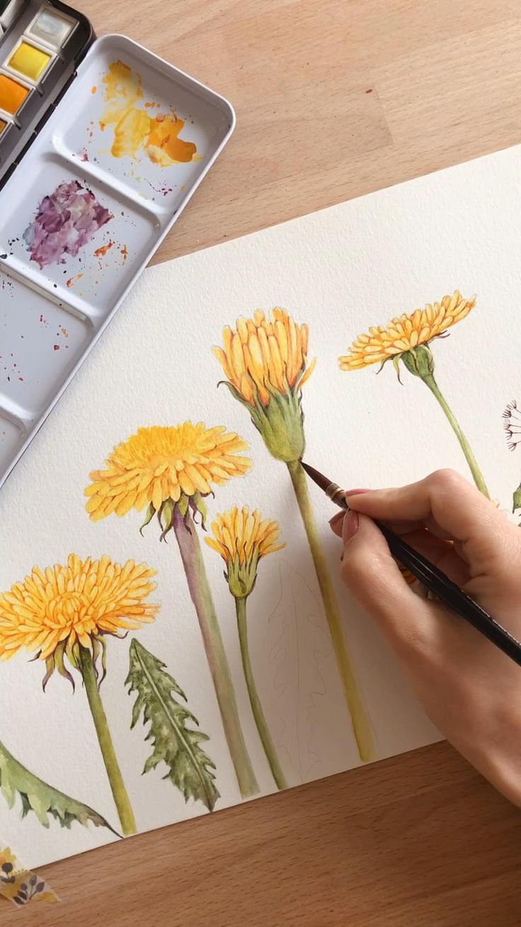 someone is painting yellow flowers with watercolors