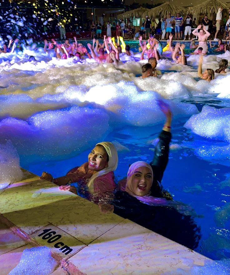 two women are floating in the water at an event