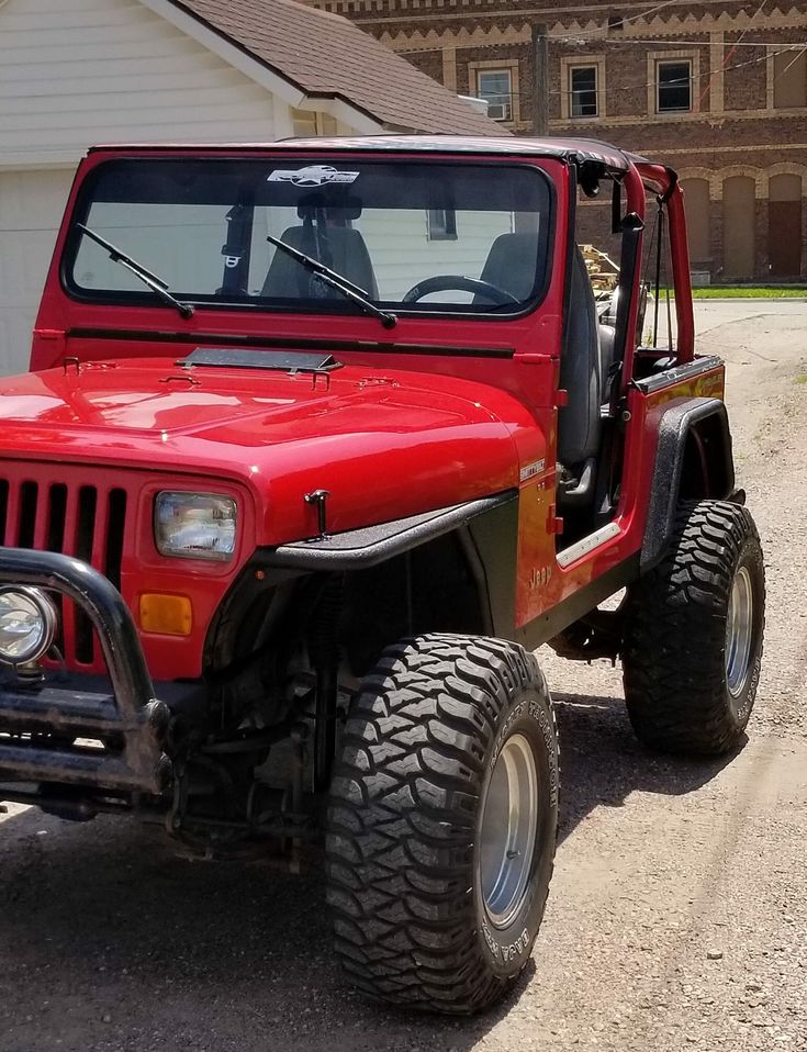 a red jeep parked in front of a house