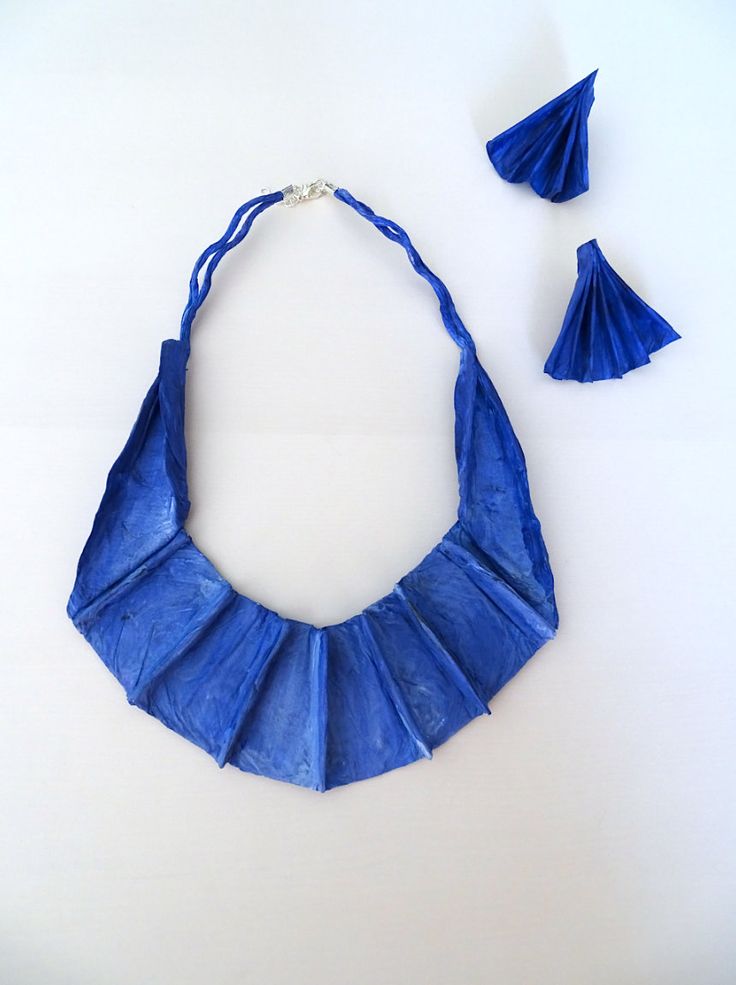 an origami necklace and earring made out of blue paper with tassels