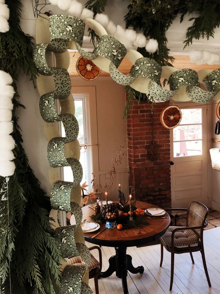 a dining room decorated for christmas with green and white decorations