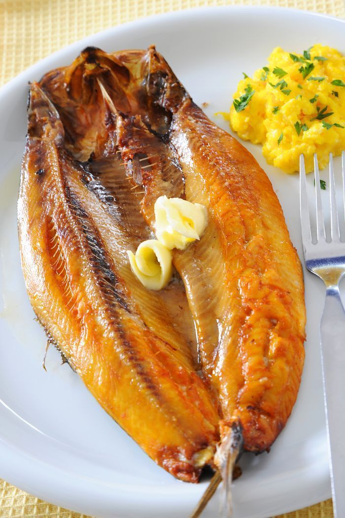 a plate with fish, mashed potatoes and a fork on the table next to it