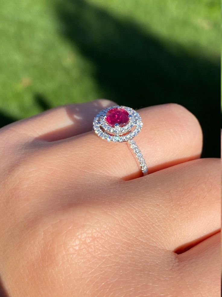 The Titania Double Halo Ruby and Diamond Ring in 14 Karat White Gold. This contemporary cocktail ring centers on a 1.05 carat ruby. The ruby is encircled by a double diamond halo with diamonds continuing down either side of the shank. The mounting has 0.58 total carats of diamonds. This modern ring is a finger size 6 3/4, yet can be adjusted to any size. Each piece has been hand selected and meticulously identified and graded by a Graduate Gemologist who has been awarded a degree by the Gemologi Ruby And Diamond Ring, Filigree Engagement Ring, Double Diamond, Antique Diamond Rings, Double Halo, Modern Ring, Filigree Ring, Antique Diamond, Diamond Halo