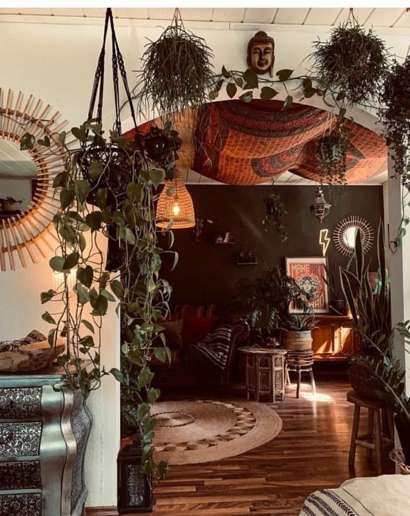 a living room filled with lots of plants and decorations on the wall next to a fire place