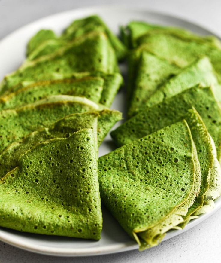 some green pancakes on a white plate