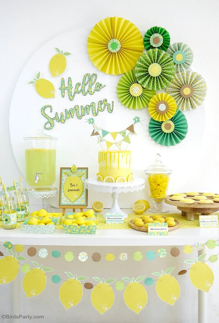 a table topped with lemons and cupcakes next to a sign that says hello summer