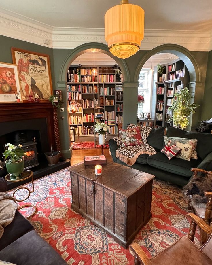 a living room filled with furniture and bookshelves next to a fire place in front of a fireplace