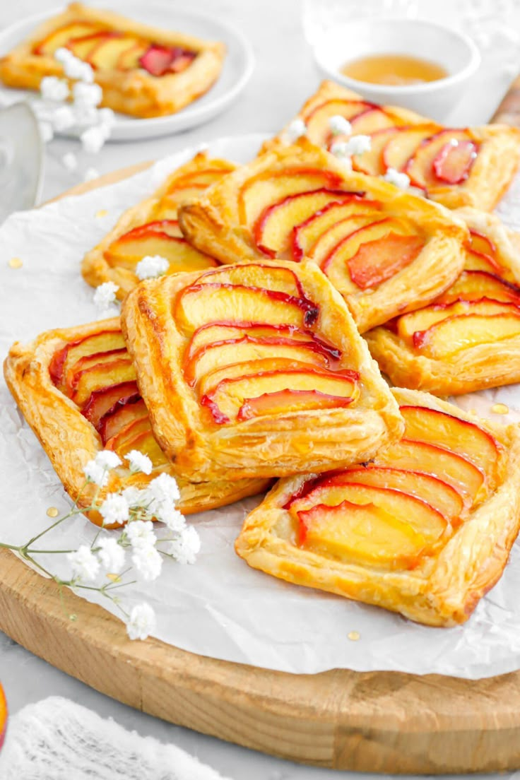 several pieces of pastry sitting on top of a white plate next to oranges and flowers