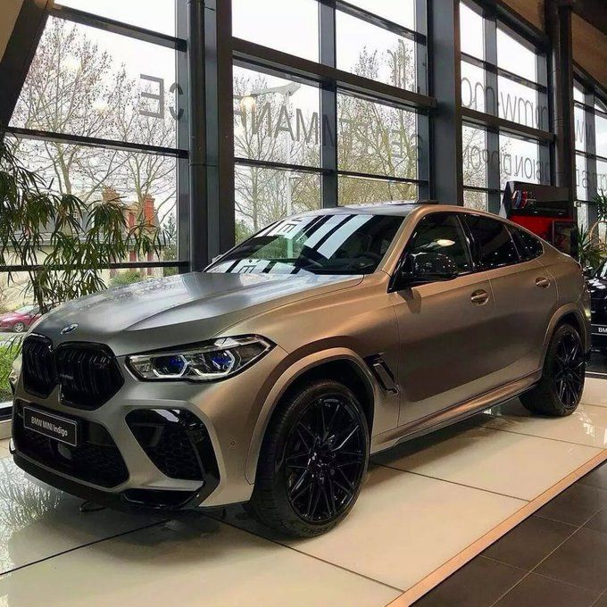 the new bmw x4 suv is on display in front of large windows at an automobile showroom