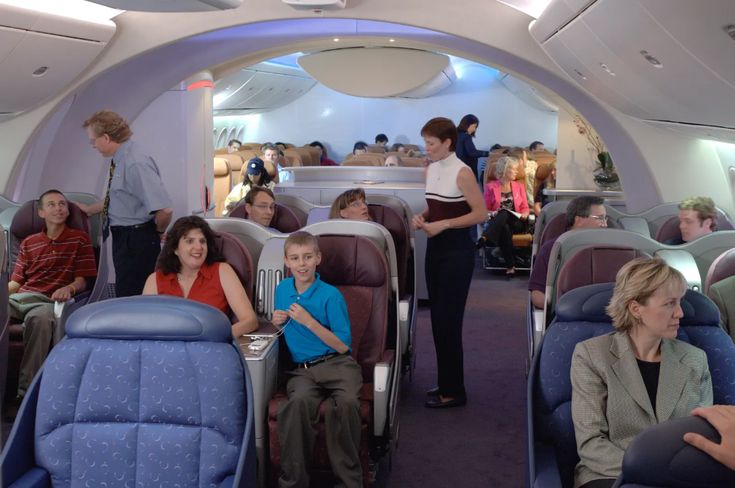 an airplane with people sitting in it and some standing around looking at the other passengers