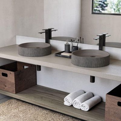 a bathroom with two sinks and towels on the counter