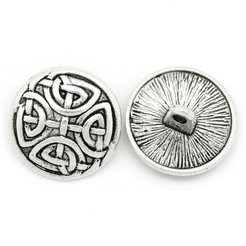 two metal buttons with an intricate design on the front and back of each button, one has