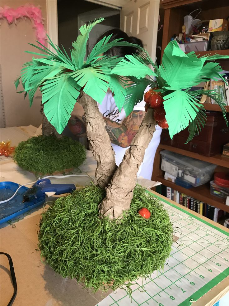 a paper mache palm tree sitting on top of a table next to a cutting board