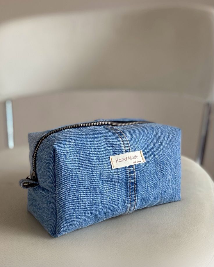 a denim pouch sitting on top of a white chair