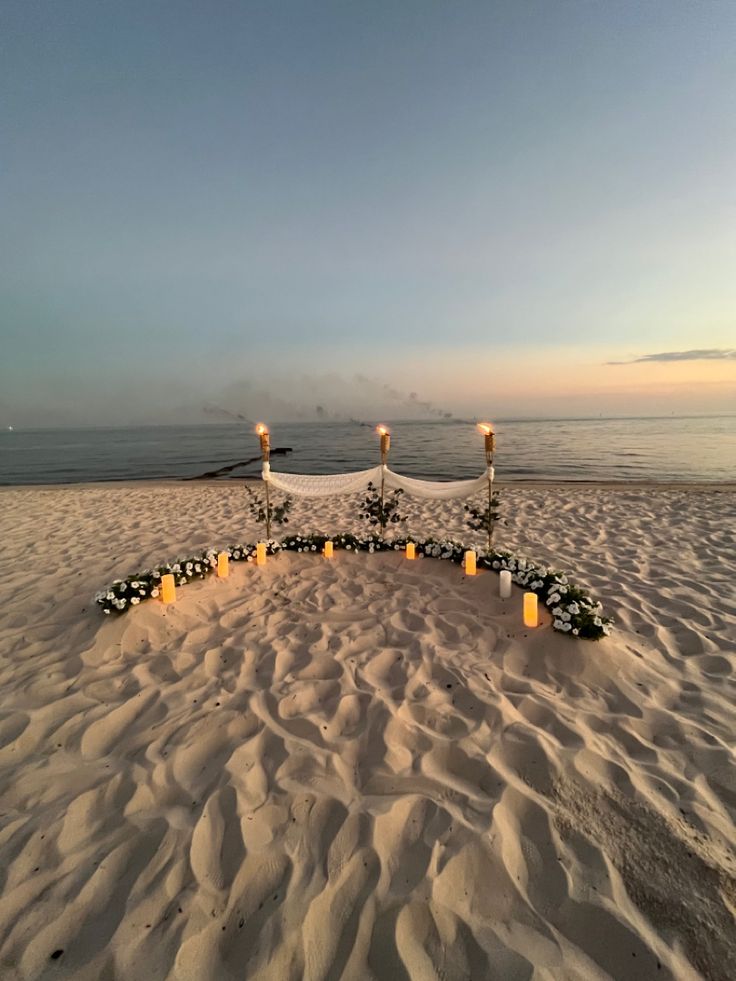 a wedding setup on the beach with candles