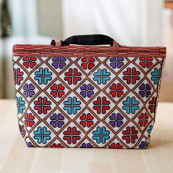 Add a touch of traditional elegance to your days with a sublime creation directly from the Uzbekistan region, the heart of the Silk Road. Crafted with classic iroki embroidery techniques, Umida Zikrillayeva's tote bag features a charming pattern in blue and red hues, all accented by matching cotton straps. The piece also has a zippered closure and an interior pocket for convenient use. Traditional Bags With Multicolor Embroidery And Motifs, Multicolor Embroidered Rectangular Shoulder Bag, Traditional Rectangular Shoulder Bag With Motifs, Rectangular Shoulder Bag With Multicolor Embroidery, Traditional Shoulder Bag For Travel, Traditional Handwoven Multicolor Embroidered Bag, Multicolor Traditional Bags With Woven Motifs, Traditional Multicolor Bags With Woven Motifs, Traditional Multicolor Embroidered Bag