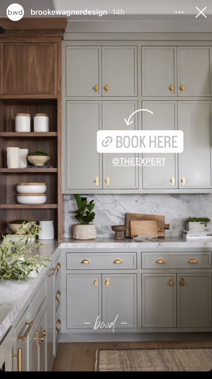 a kitchen with gray cabinets and white counter tops, an open book shelf is above the sink