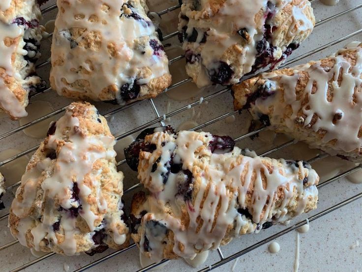 blueberry scones with icing on a cooling rack