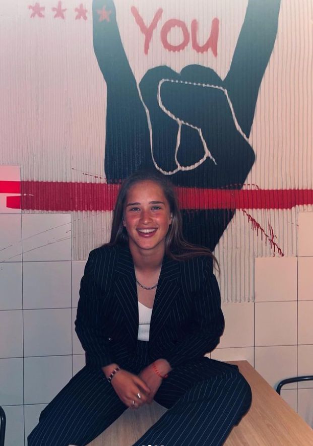 a woman sitting on top of a wooden table in front of a sign that says you