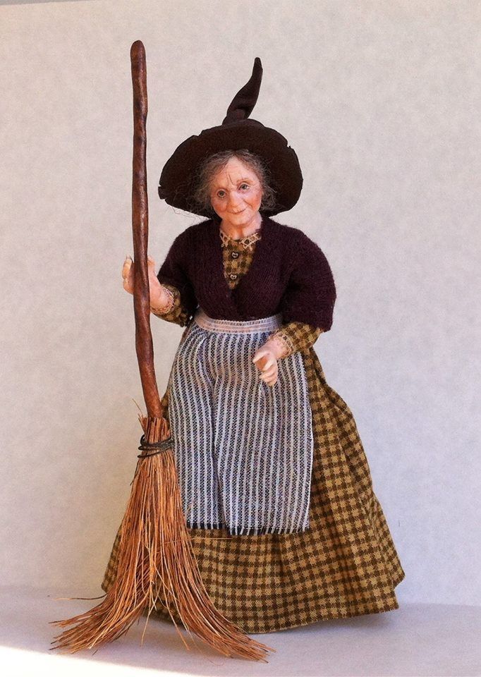 an old fashioned doll is holding a broom