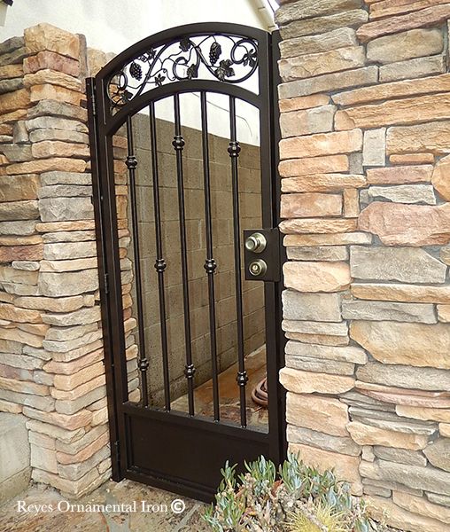 an iron gate in front of a stone wall