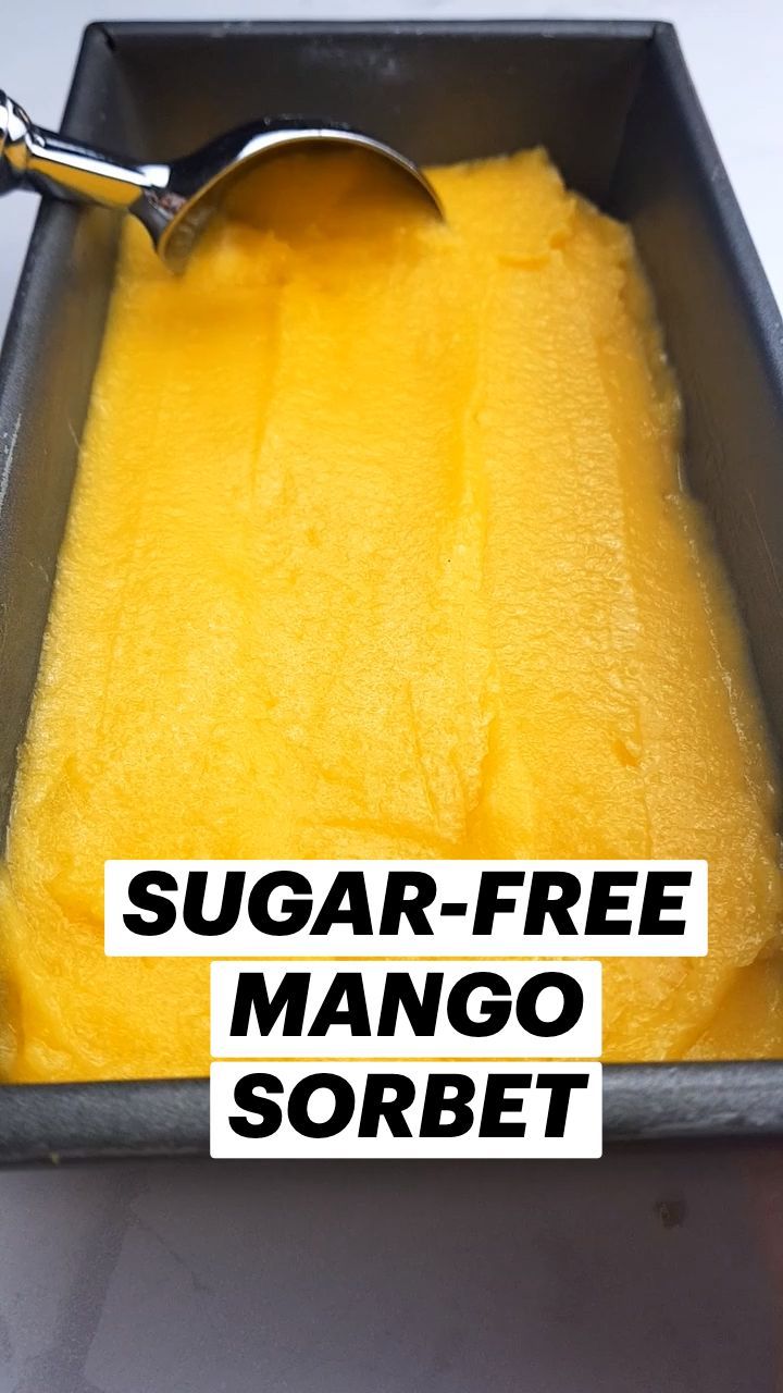 a scoop of sugar - free mango sorbet in a metal pan with a spoon