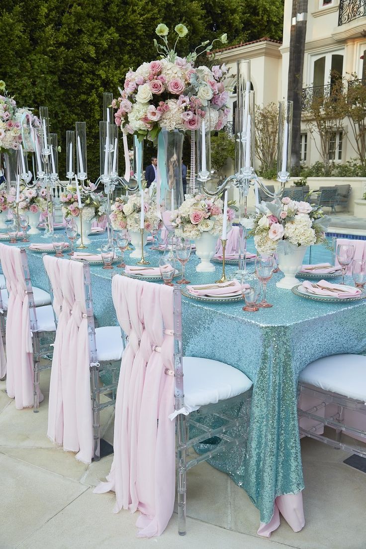 a table set up with pink and white flowers