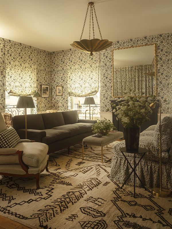 a living room filled with furniture and a large mirror on the wall above it's headboard