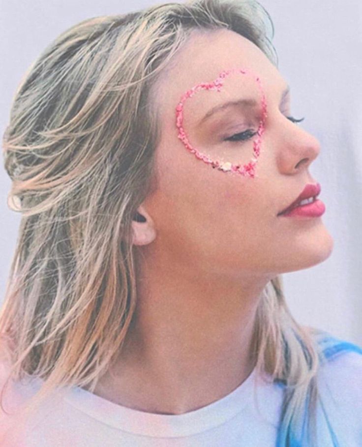 a woman with her face painted pink and the word love spelled out in front of her