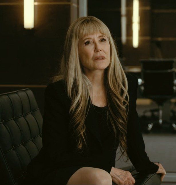 a woman sitting in an office chair looking off into the distance