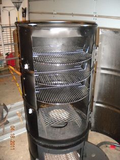 a large black stove sitting inside of a garage next to a wall mounted heater