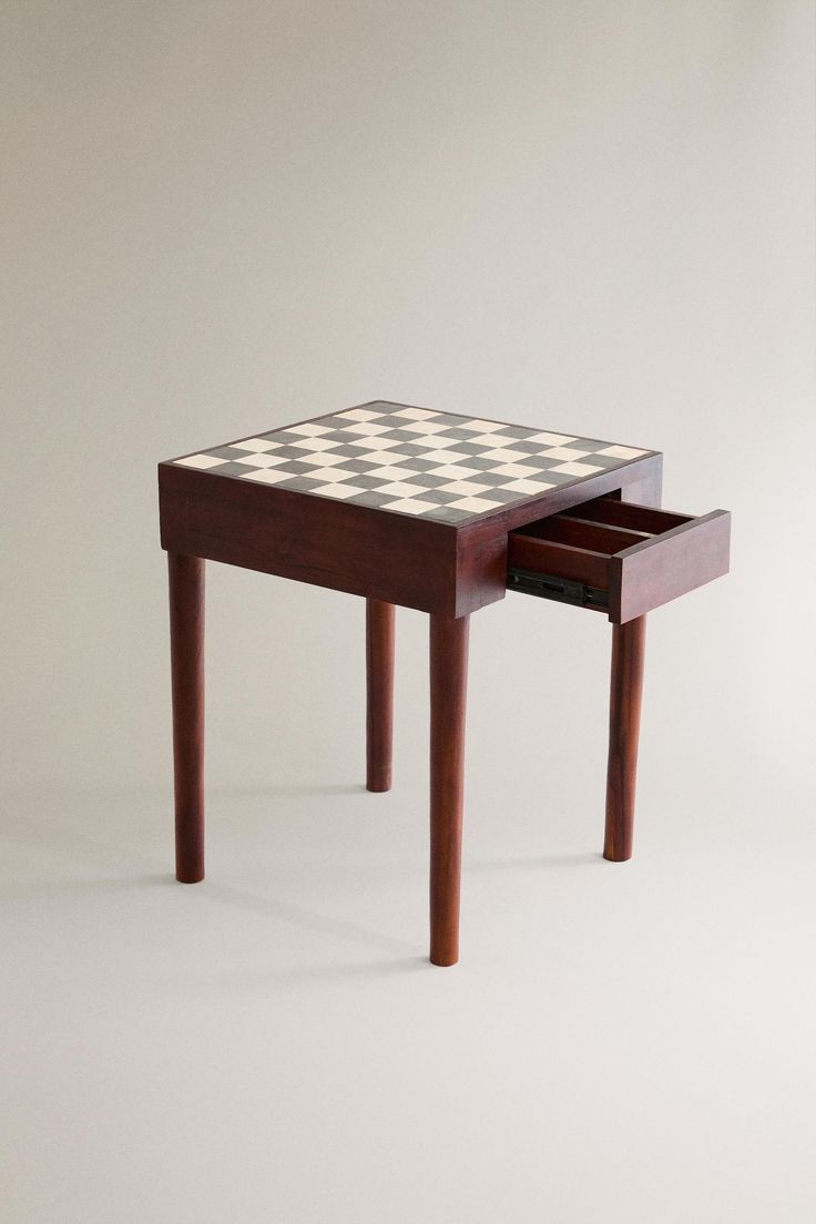 a wooden table with a checkerboard design on the top and drawer underneath it