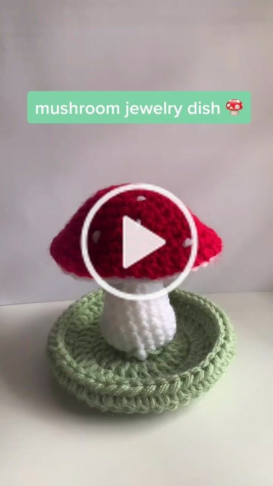 a crocheted mushroom is sitting on top of a green object with a white button