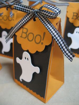 three halloween treat bags tied together with black and white ribbon, one has a ghost on it