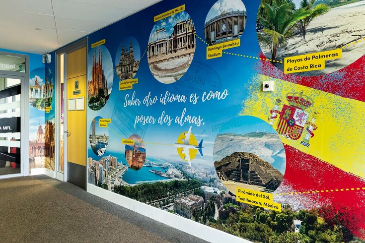 a large mural on the side of a building with spanish words and pictures around it