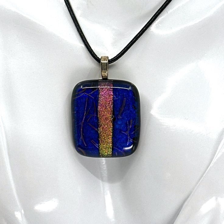 Beautiful dichroic glass pendant, handmade by me, Jason Hoffman, here in Eau Claire, Wisconsin. This stunning, one-of-a-kind piece measures 1.75" in height, and 1.25" in width, is topped with a sterling silver plated bail, and comes with a 20" black leather cord upon purchase. Iridescent Glass Necklaces As Gifts, Iridescent Large Pendant Jewelry Gift, Iridescent Glass Jewelry As Gift, Iridescent Glass Jewelry Gift, Iridescent Glass Jewelry For Gifts, Handmade Glass Jewelry With Rectangular Pendant, Handmade Glass Square Pendant Jewelry, Handmade Glass Rectangular Pendant Jewelry, Handmade Square Glass Pendant Jewelry