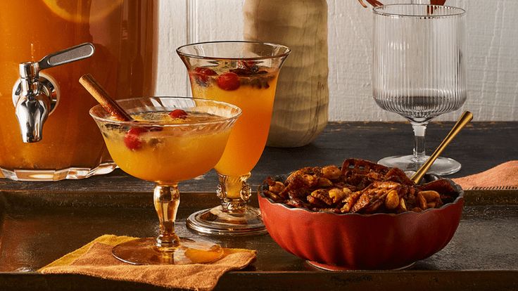 there are three different drinks in the glass bowls on the counter top, one is orange