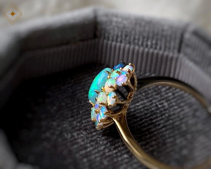 an opal ring sitting on top of a cloth