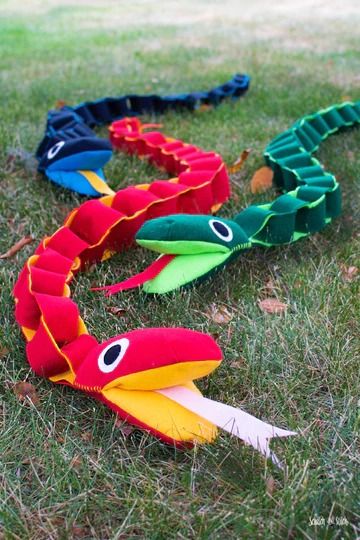 several colorful kites laying on the grass in a circle with eyes and tails attached to them