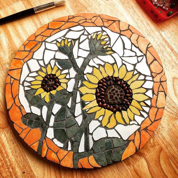 a sunflower mosaic on a wooden table