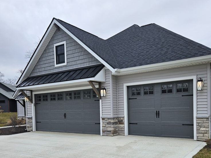 a house with two garages in the front and one on the other side that is gray