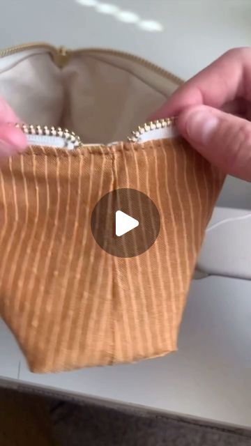 someone is opening up a small purse with zippers on the inside, and there is a video about how to sew