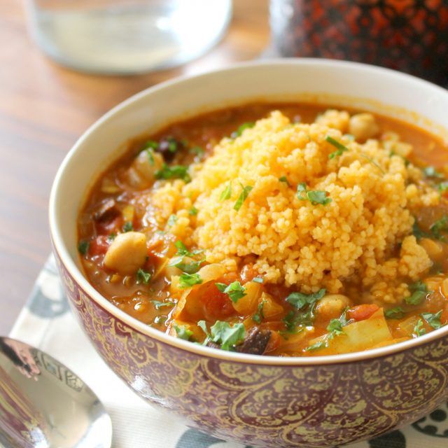 a bowl filled with soup and rice on top of a table