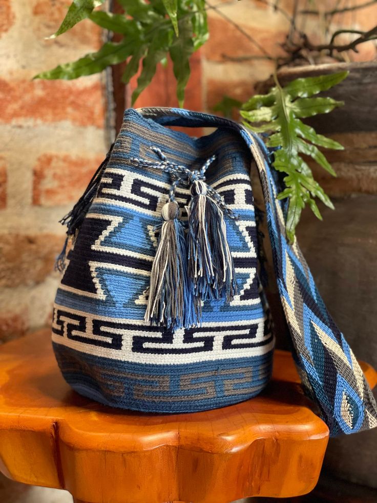 Handmade by Ecuadorian artisans with high-quality natural fibers, this ethnic bag is perfect for carrying your belongings while adding a bohemian touch to your style. It can be carried on the shoulder or as a shoulder bag, as you prefer! Called "shigras" in Ecuador, they are made in up to 5 days using traditional techniques, being highly valued for their resistance and durability. Furthermore, the elaboration process is an art in itself and represents a way of preserving the culture and traditio Bohemian Brown Crochet Bag, Fair Trade, Blue Handwoven Bucket Bag, Bohemian Natural Bucket Shoulder Bag, Bohemian Natural Color Bucket Shoulder Bag, Artisan Handwoven Crochet Bag For Travel, Artisan Handwoven Crochet Travel Bag, Traditional Bucket Crochet Bag For Everyday Use, Artisan Handwoven Straw Bag For Daily Use, Bohemian Jute Bucket Bag For Travel