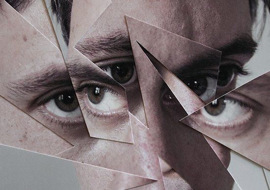 a man's face is surrounded by multiple pieces of paper that have been cut in half